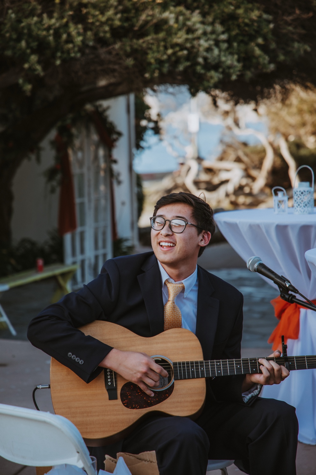Noah singing and playing acoustic guitar at a wedding event